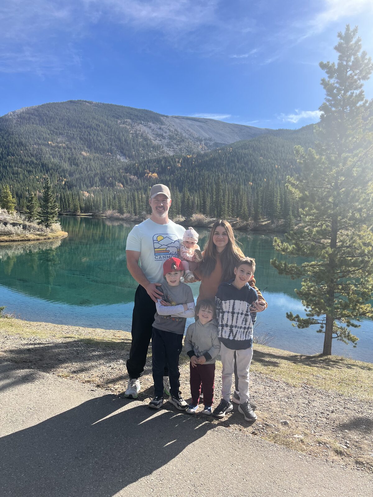 Greg and his family by a lake in the Alberta mountains